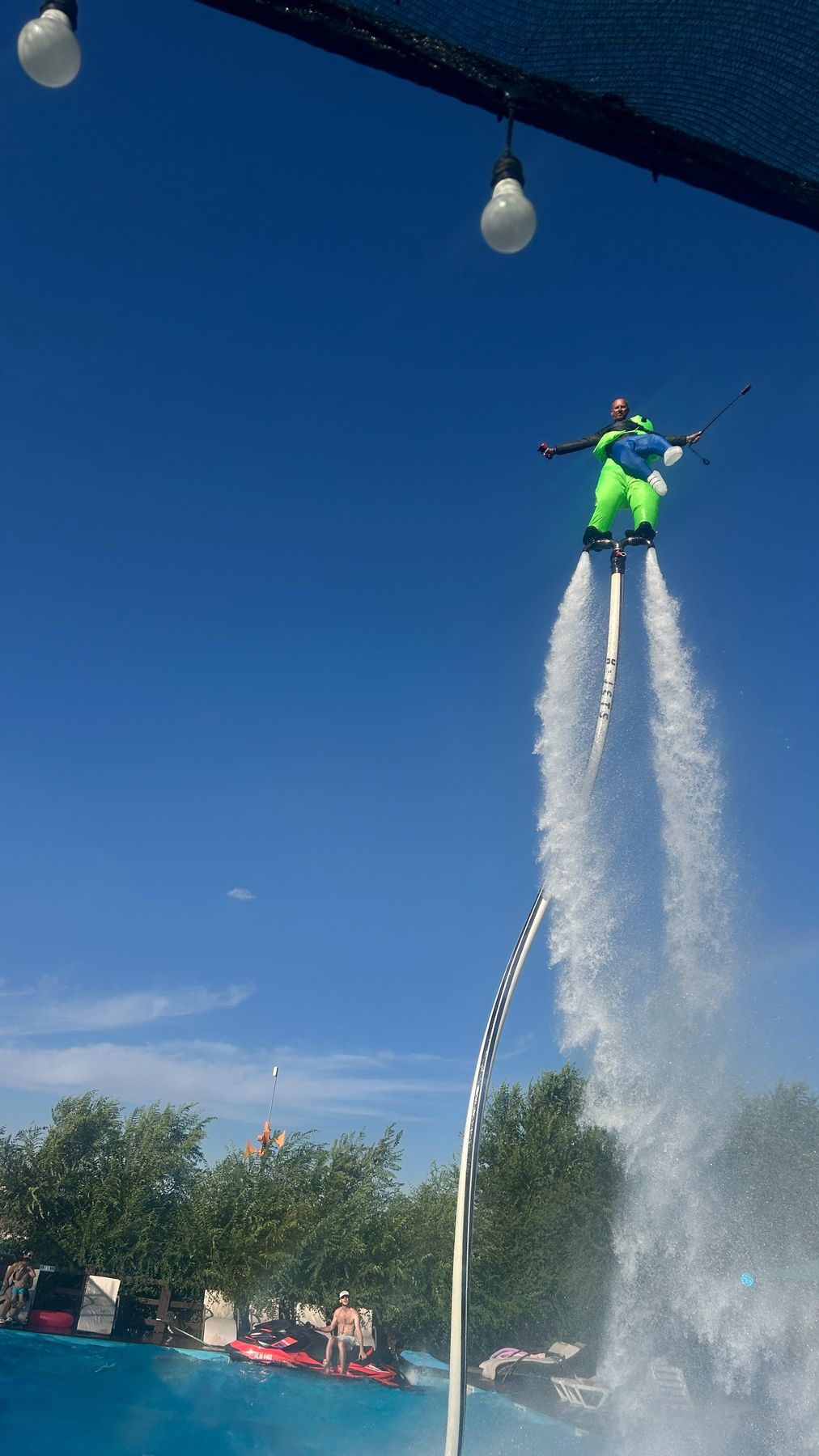 Character flyboard show in a bright inflatable suit over a pool on a clear Phuket day